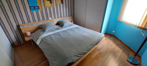 une chambre avec un lit dans une pièce aux murs bleus dans l'établissement Très jolie maison avec piscine, à Soultz-Haut-Rhin