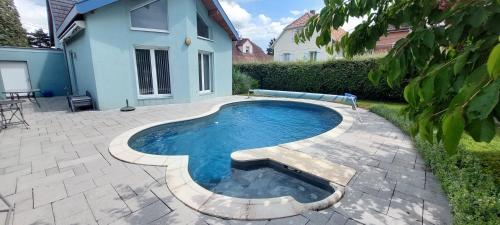 - une petite piscine dans une cour à côté d'une maison dans l'établissement Très jolie maison avec piscine, à Soultz-Haut-Rhin