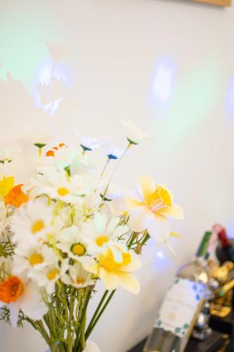 a vase filled with white flowers on a table at Mina Pool Villa in Ban Huai Yai