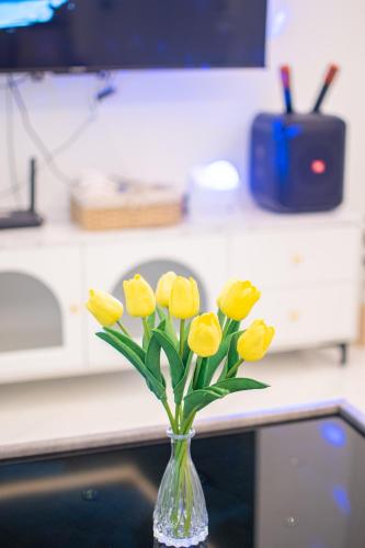 a vase filled with yellow flowers on a counter at Mina Pool Villa in Ban Huai Yai