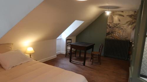 a bedroom with a bed and a desk in a attic at La Maison du Griffoul BB à Salles la Source cascade et terroir in Salles-la-Source