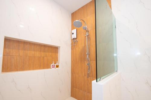 a bathroom with a shower with a glass door at Mina Pool Villa in Ban Huai Yai