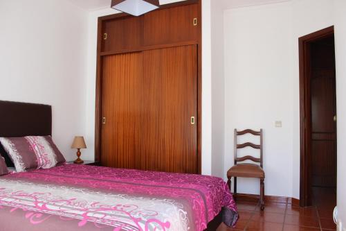 1 dormitorio con 1 cama y puerta de madera en Baleal Holiday Apartment, en Baleal