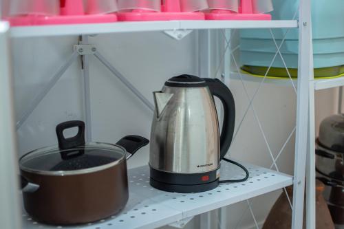 a tea kettle and a pot on a shelf at Mina Pool Villa in Ban Huai Yai