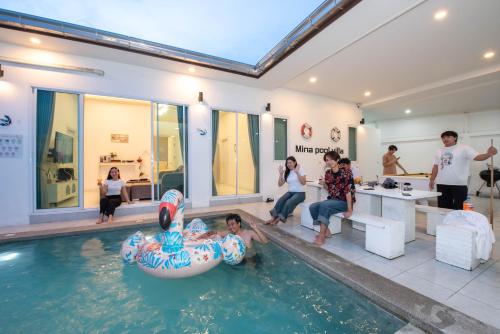 a group of people in a swimming pool at Mina Pool Villa in Ban Huai Yai