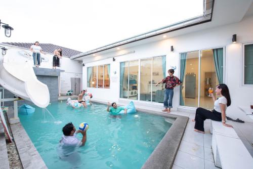 a group of people playing in a swimming pool at Mina Pool Villa in Ban Huai Yai
