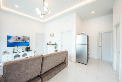 a living room with a couch and a refrigerator at Mina Pool Villa in Ban Huai Yai
