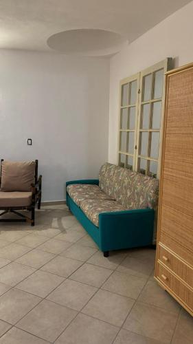 Sofá azul en una habitación con silla en Casa centralissima Torre dell Orso 100m dal mare, en Torre dell'Orso