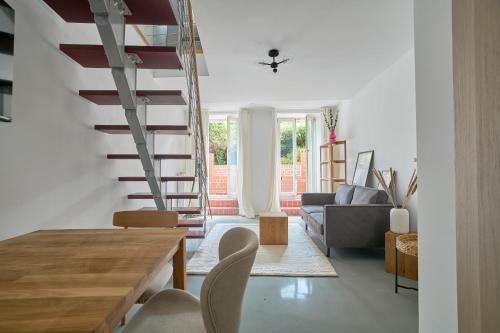 a living room with a staircase and a couch at Ruhiges zentrales Maisonette-Loft in Berlin in Berlin