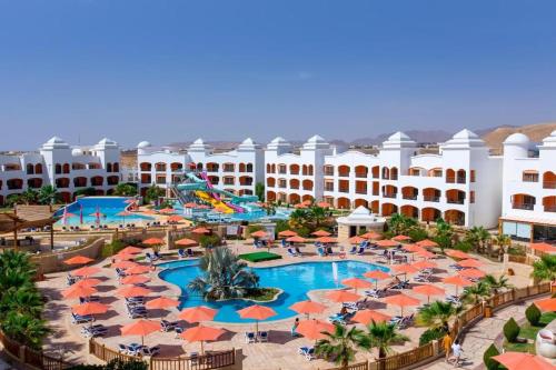 an aerial view of a resort pool with orange umbrellas at Fun & Sun Naama Waves in Sharm El Sheikh