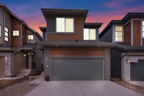 a house with a garage at sunset at Luxury AC Sleeps 7 in Edmonton