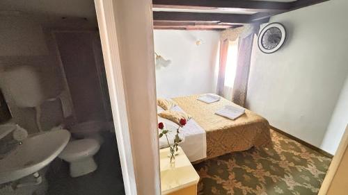 uma pequena casa de banho com uma cama e um lavatório em Casa Lin Venice Zimmer em Veneza