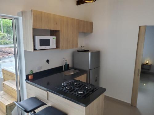 a small kitchen with a stove and a refrigerator at Cloud9h in Medellín