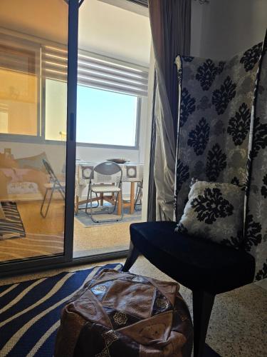a living room with a chair and a table at Sayda Appart Hotel in Chebba