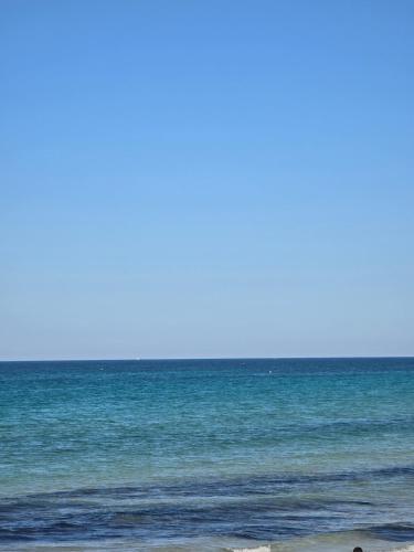 a person standing on the beach near the ocean at Sayda Appart Hotel in Chebba