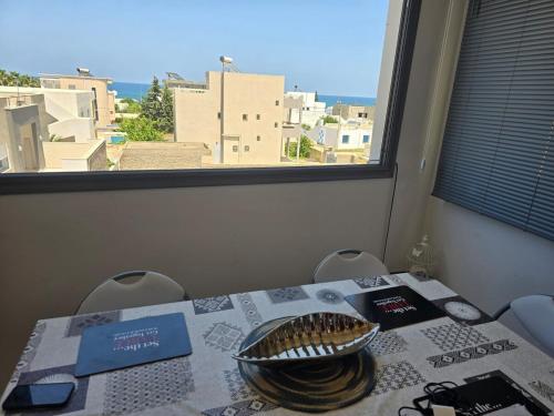 a table with a view of a city from a window at Sayda Appart Hotel in Chebba