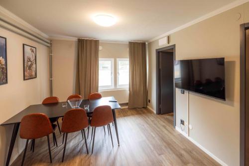 a dining room with a table and chairs and a television at Camp Gielas, Arvidsjaur in Arvidsjaur