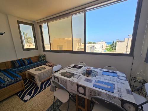 a room with a table and chairs and a couch at Sayda Appart Hotel in Chebba