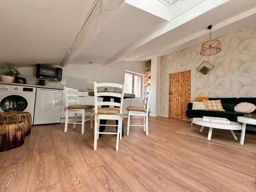 a living room with a couch and a table and chairs at Charmant Studio indépendant in Vézénobres