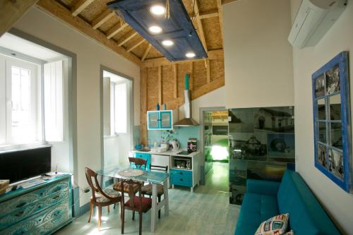 a living room with a blue couch and a table at Casas da villa - Apartments in Ericeira