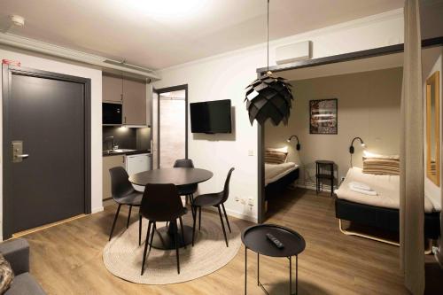 a room with a table and chairs and a bedroom at Camp Gielas, Arvidsjaur in Arvidsjaur