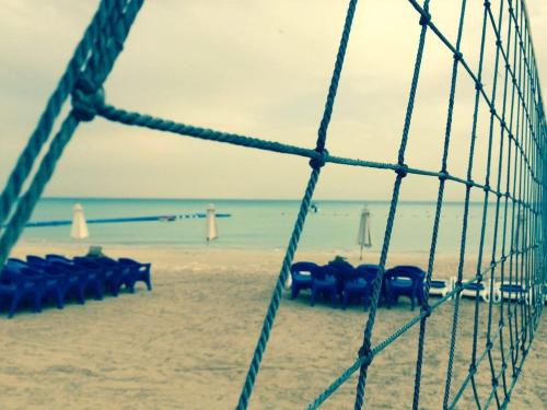 a group of chairs on a beach with the ocean at Elite Residence Aqua Park in Ain Sokhna
