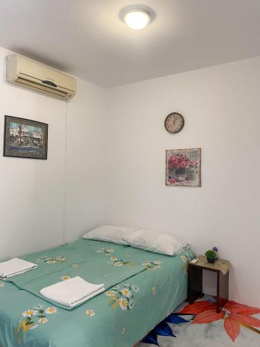 a bedroom with a bed and a clock on the wall at Secret Garden Mostar in Mostar