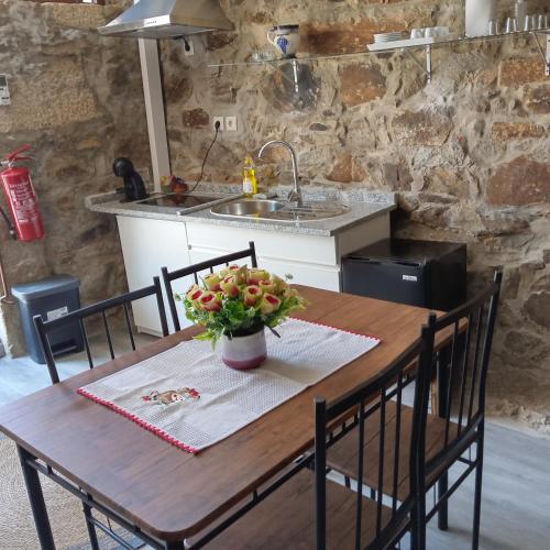 a kitchen with a wooden table with a vase of flowers on it at D. Maria São Pedro de Balsemão in Lamego