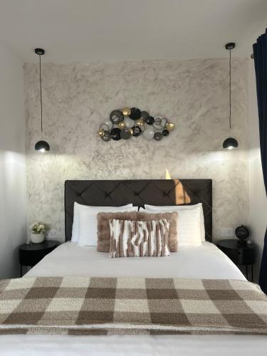 a bedroom with a large bed with a checkered blanket at CASAMORE Rentals in Braşov