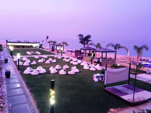 a group of pink chairs on the beach at night at Elite Residence Aqua Park in Ain Sokhna