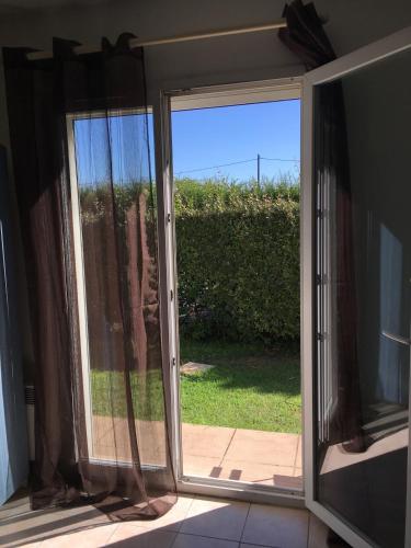 une porte coulissante en verre ouverte avec vue sur une cour dans l'établissement Studio G Baillargues Montpellier Golf de Massane, à Baillargues