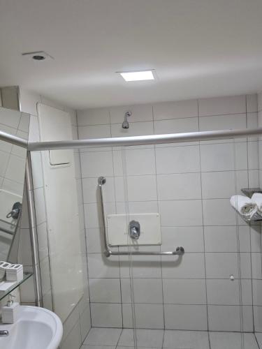 a bathroom with a shower with a toilet and a sink at Beach Class Executive in Recife