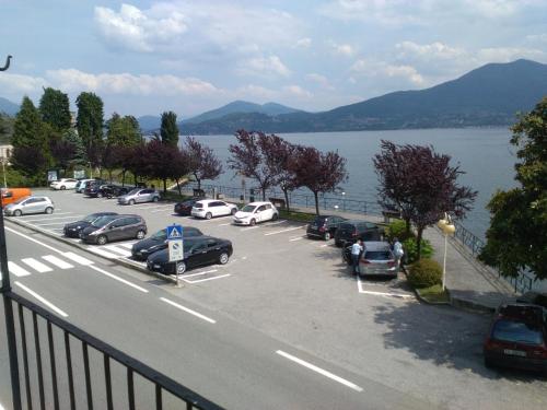 a parking lot with cars parked next to a body of water at Il Vapore in Oggebbio