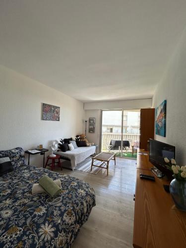 un salon avec un lit et un canapé dans l'établissement Studio - Menton vue mer, à Menton