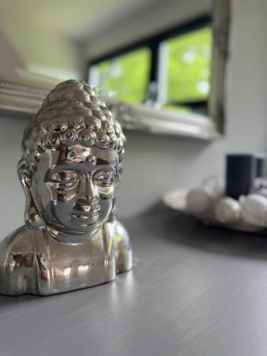 a silver statue of a buddha sitting on a table at Ferienhaus Heimatliebe in Horperath