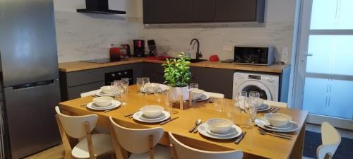 une table de salle à manger avec des chaises et une cuisine dans l'établissement 8 pers, Maisonnette en bordure de forêt vosgienne, à Barbey-Séroux
