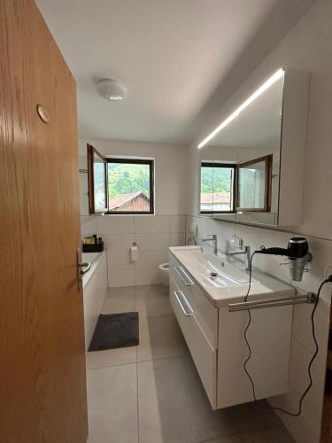 a bathroom with a sink and a mirror at Allgäu Moments Oberstaufen in Oberstaufen