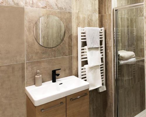 a bathroom with a sink and a mirror at Hôtel-Restaurant Belle'man in Longevelle-sur-Doubs