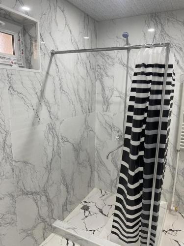 a bathroom with a black and white shower curtain at Rest home in Chʼkalovka