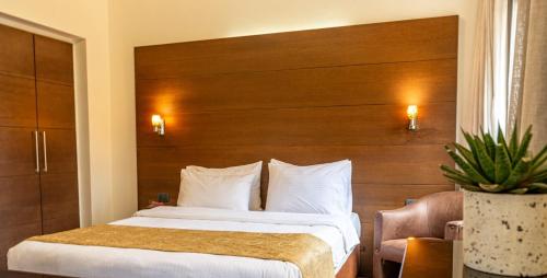 a bedroom with a large bed with a wooden headboard at Britannia Suites in Beirut