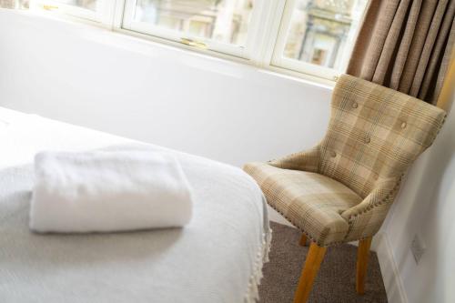 a room with a bed and a chair next to a window at Taypark River View Apartment in Dundee