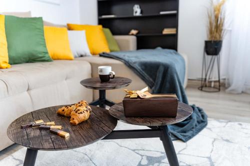 ティミショアラにあるPanoramic Apartment with public Parking TPARK paid by us in Timisoaraのテーブル2つとソファのあるリビングルーム