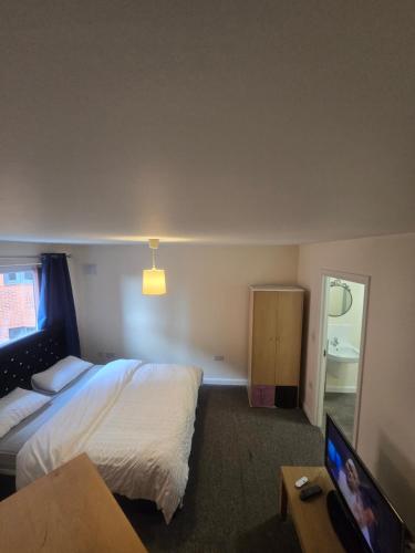 a hotel room with a bed and a television at Private Ensuite room in Wolverhampton city centre in Wolverhampton