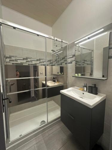 une salle de bain avec une douche en verre et un lavabo dans l'établissement Charmant appartement climatisé, à Sérignan