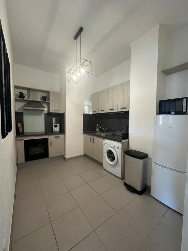 une cuisine avec un réfrigérateur et une machine à laver dans l'établissement Charmant appartement climatisé, à Sérignan