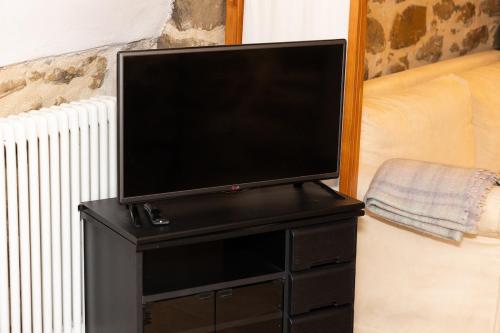 a flat screen tv on top of a black stand at Appartamento La Grotta - Design Artigianale in Manciano