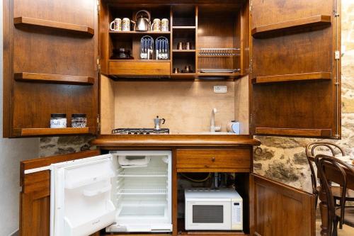 a kitchen with an open refrigerator and a microwave at Appartamento La Grotta - Design Artigianale in Manciano
