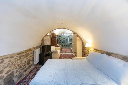 a bedroom with a large bed in a room with an archway at Appartamento La Grotta - Design Artigianale in Manciano
