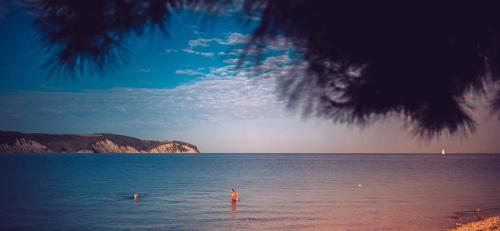 two people swimming in the water on a beach at Appartamento Da Andrea in Izola