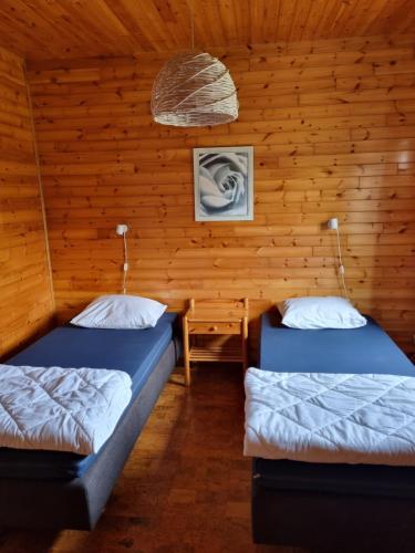 een kamer met twee bedden in een houten hut bij Chalet Lizelle in Durbuy